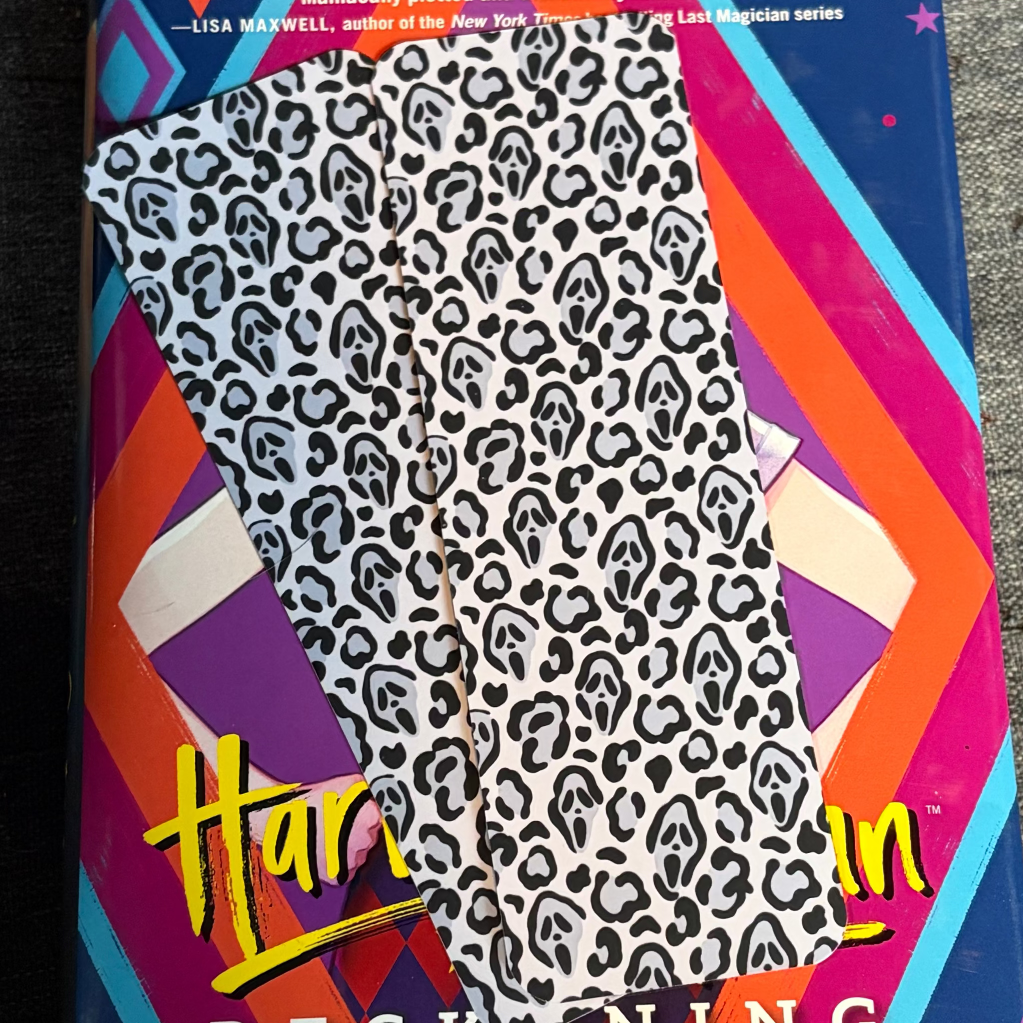 Black and white spooky cheetah print bookmark with hidden slasher-mask faces throughout the pattern
