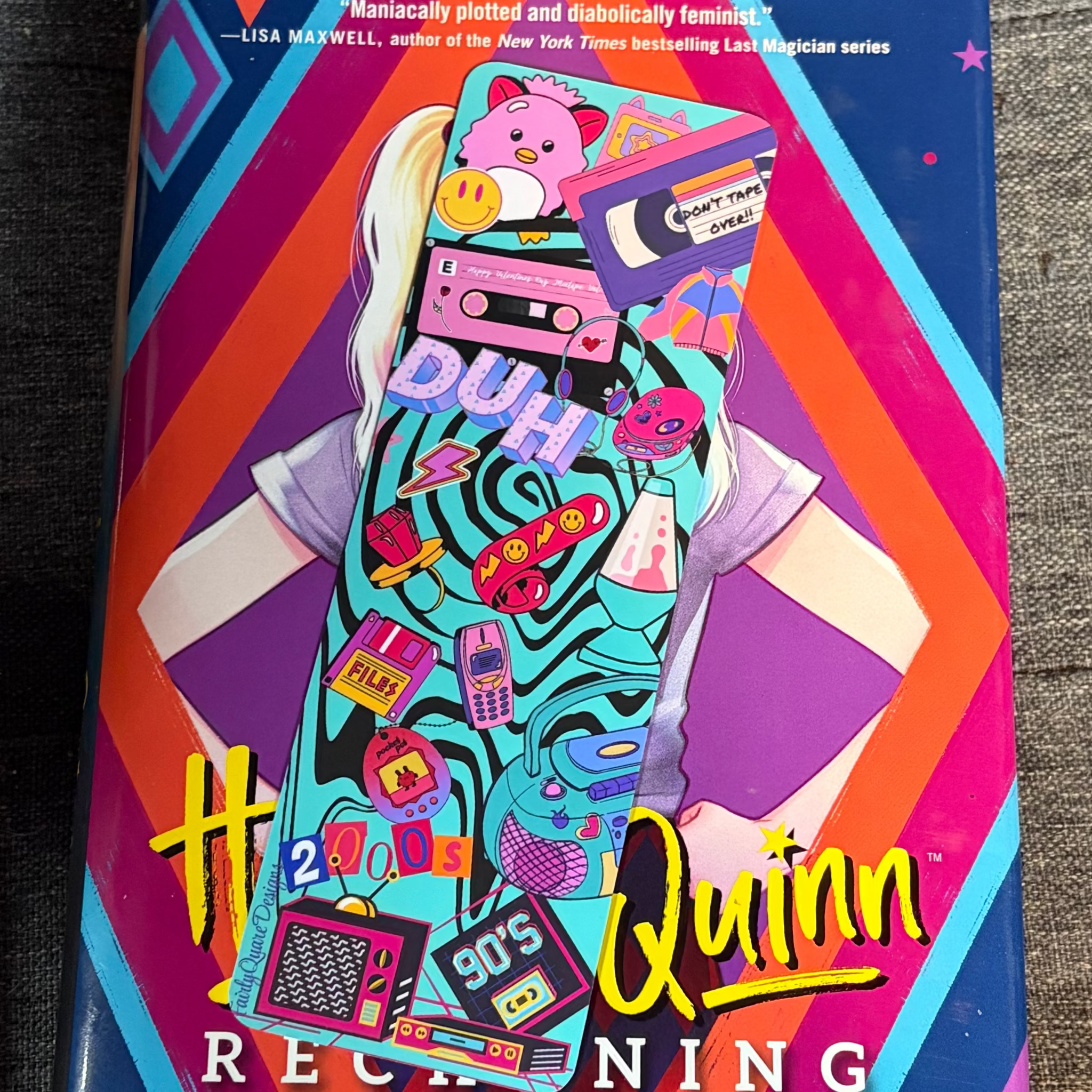 Colourful 1990s nostalgia bookmark featuring a Furby, Tamagotchi, cassette tape, VHS, CDs, lava lamp, floppy disk and old television
