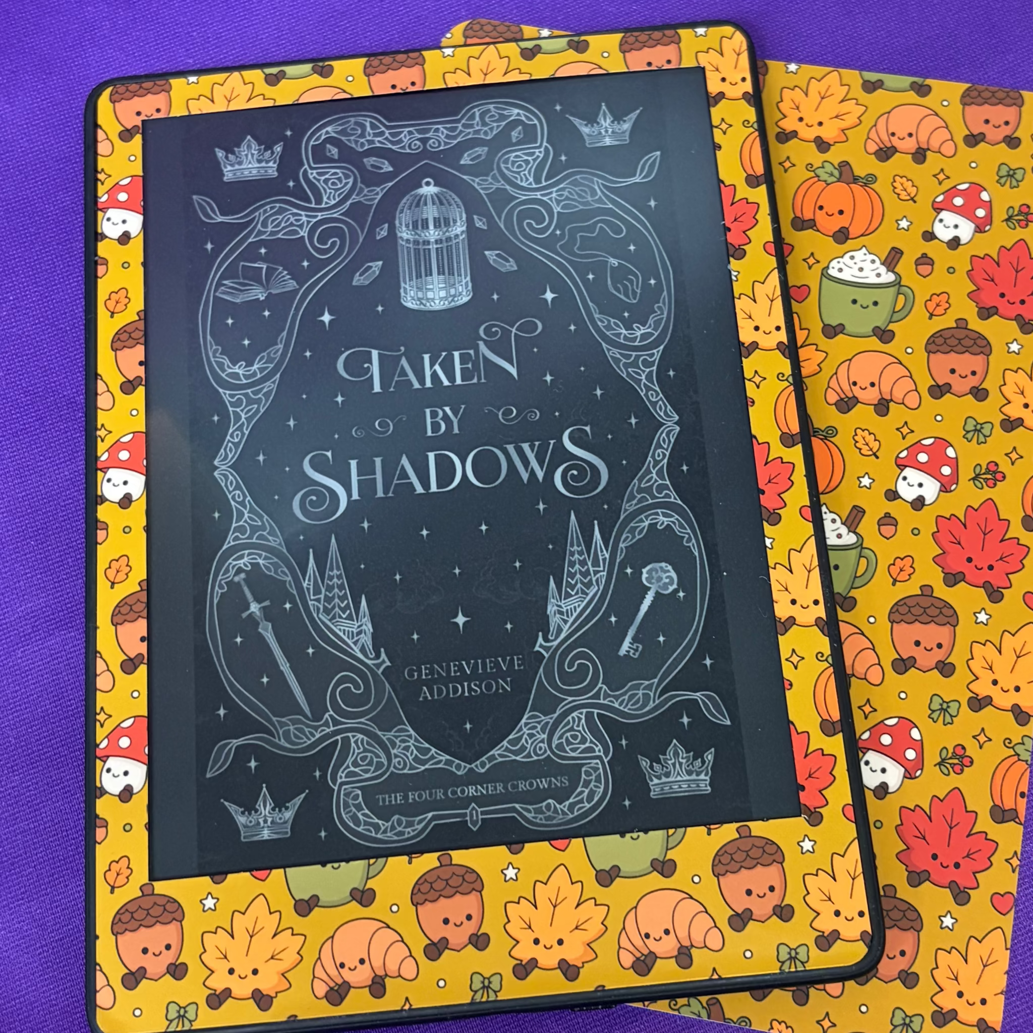 Mustard yellow Kindle front skin patterned with pumpkins, autumn leaves, acorns, mushrooms, croissants and warm drinks
