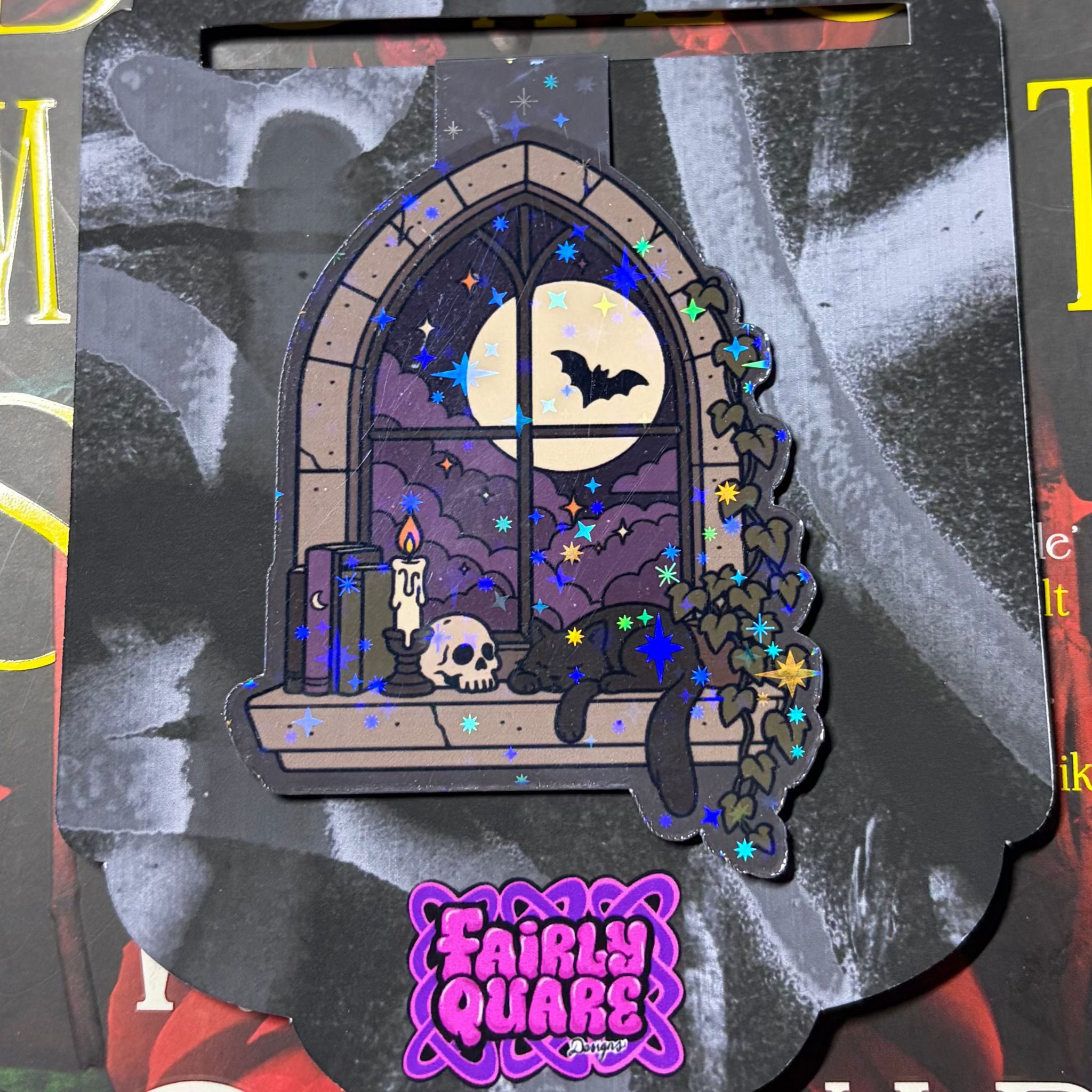 Gothic magnetic bookmark featuring a moonlit arched window, flying bats, candle, skull, black cat and vines with star glitter laminate
