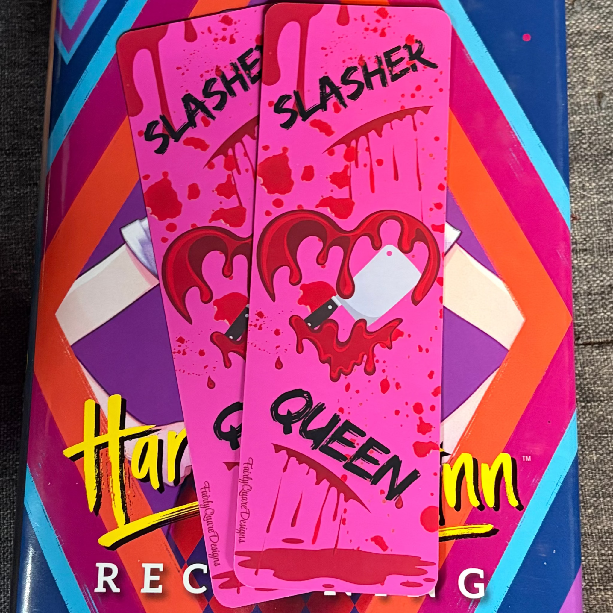 Hot pink Slasher Queen bookmark featuring a dripping red heart pierced by a knife and blood splatter details
