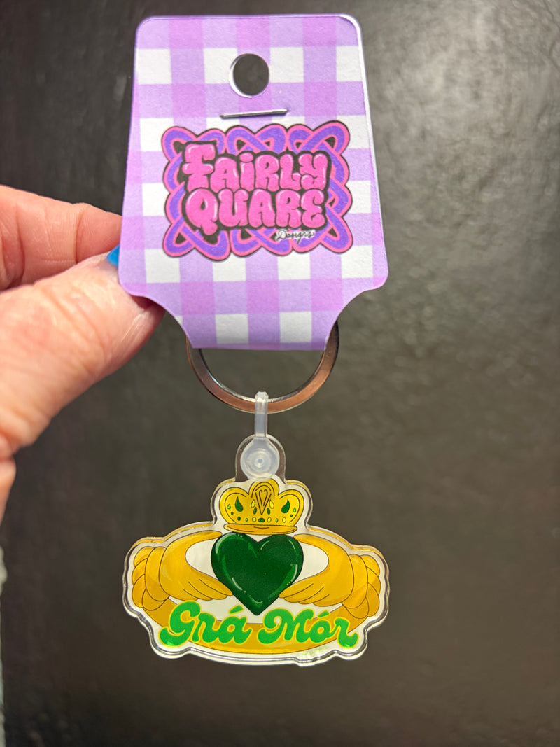 Grá Mór Claddagh acrylic keyring by Fairly Quare Designs featuring gold Claddagh hands holding a green heart with Grá Mór lettering
