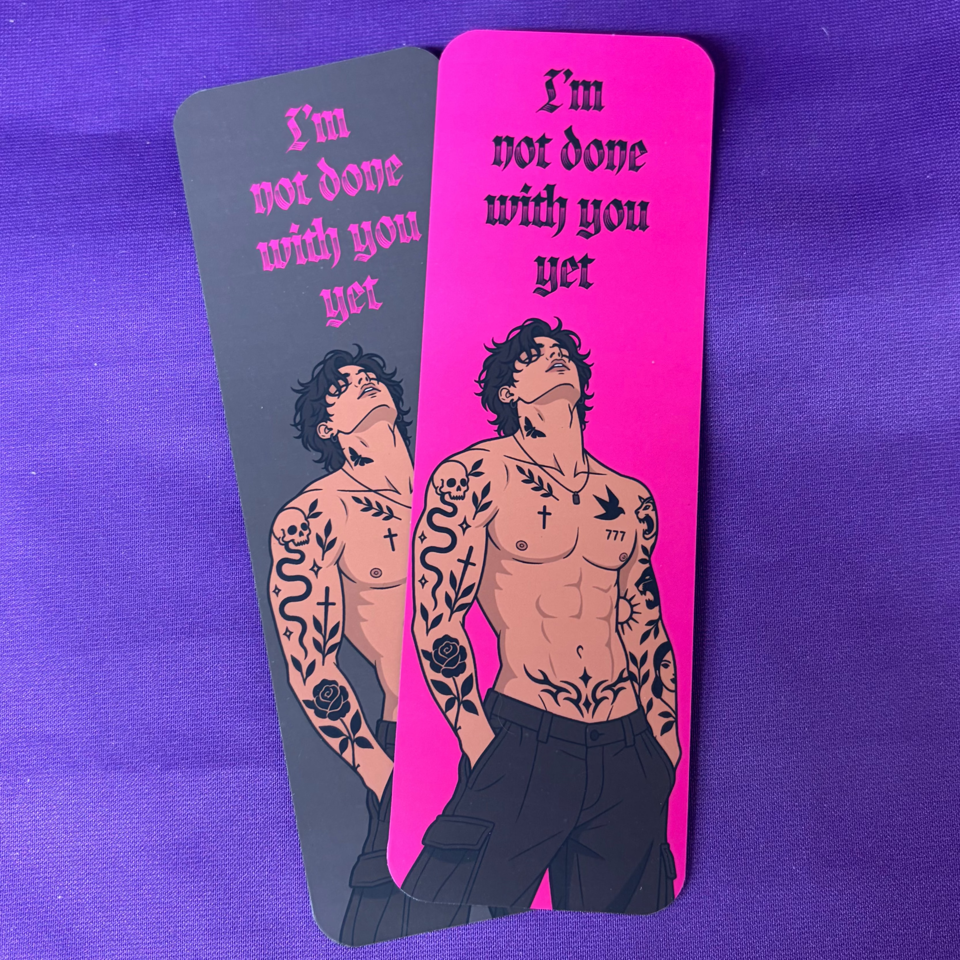 Double-sided dark romance bookmark in hot pink and black featuring a tattooed shirtless man and the words I’m Not Done With You Yet