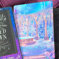 Blue and pink fantasy Kindle backing insert featuring an icy palace courtyard with ornate arches, columns and a frozen fountain
