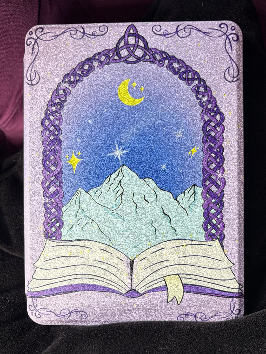 Kindle Hard Flip Case - Celtic Dreamer. Purple Case with dreamy Snow capped mountains and a celestial backdrop. A magical Celtic doorway appears from an open book.&nbsp;

3 in 1 Flip case for Kindle. Features auto wake/sleep function, detachable magnetic flip cover with a clear fitted backing case which can be used independently of the flip case. Case also converts into a flip stand and has a sturdy handle for one handed reading. Compatible with your existing magnetic grip and stand accessories.