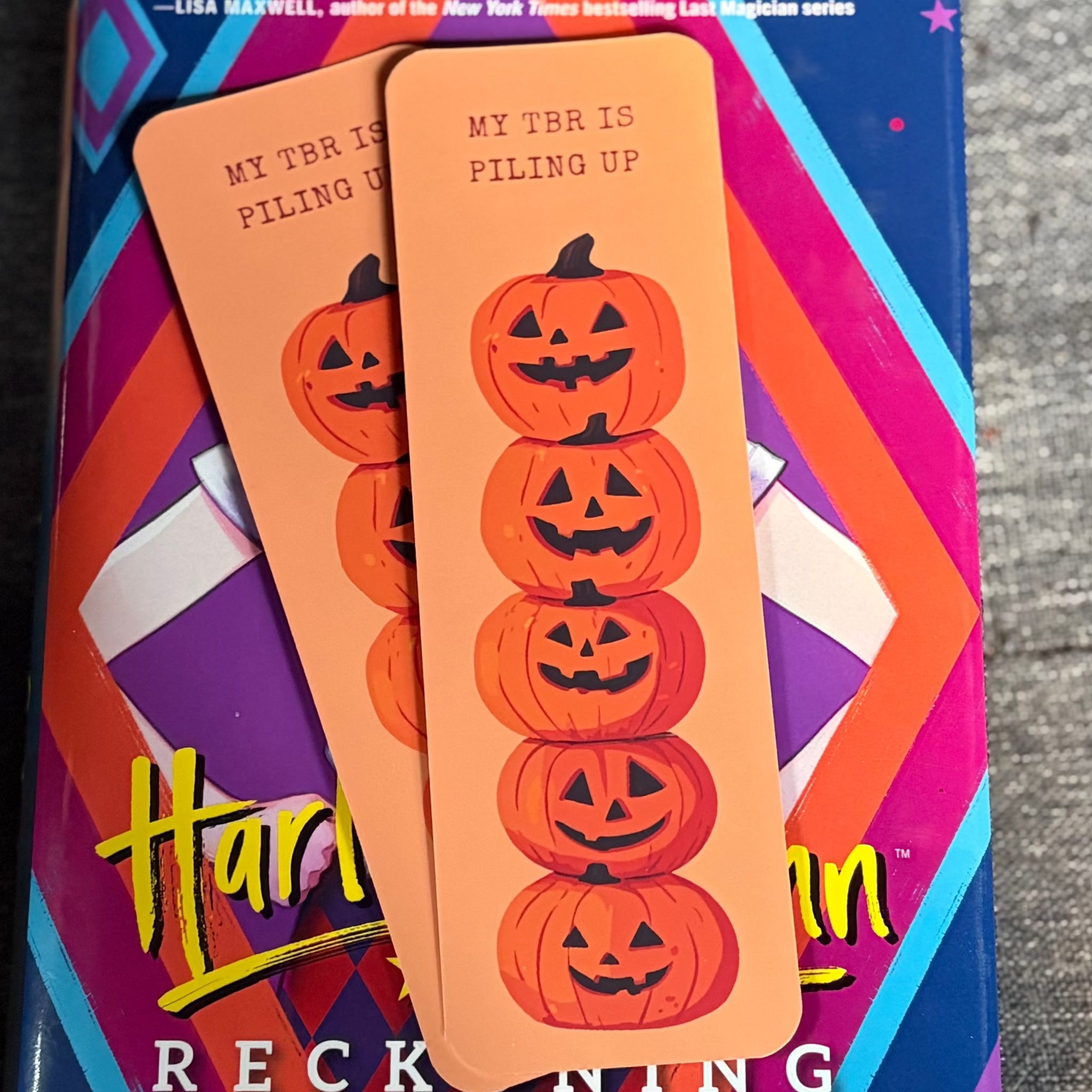 Orange My TBR Is Piling Up bookmark featuring a tall stack of smiling jack-o’-lantern pumpkins
