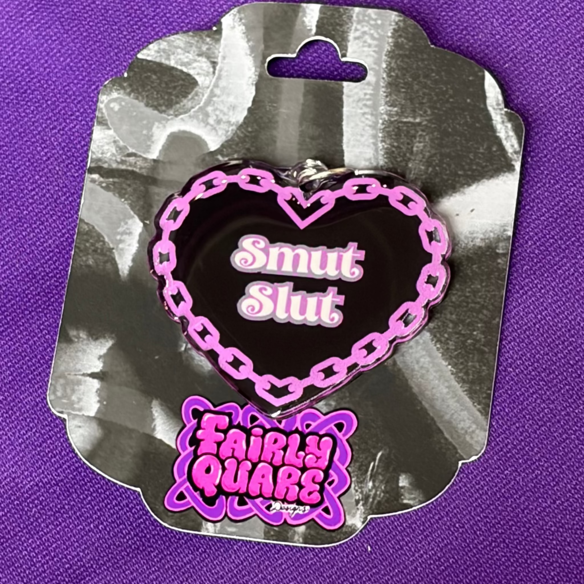 Black heart-shaped USB-C Kindle and phone charm with a purple chain border and the words Smut Slut in white and purple
