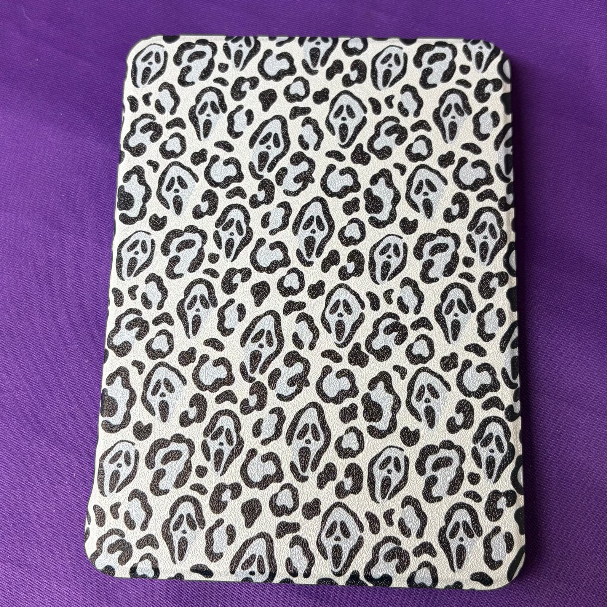 Black and cream Spooky Cheetah Kindle case featuring cheetah spots with hidden Ghostface-style masks
