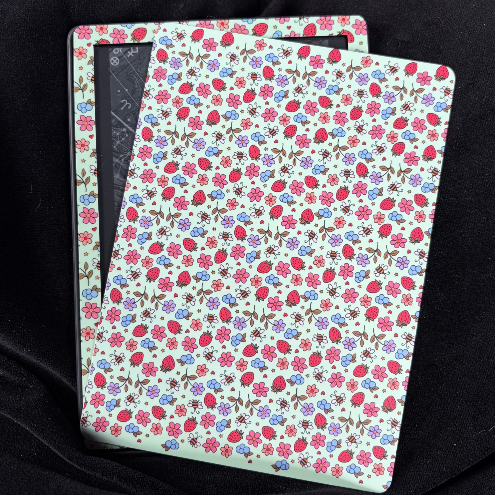 Strawberry Meadow Kindle backing insert with pink flowers, strawberries, blueberries and little bees on a pale mint background
