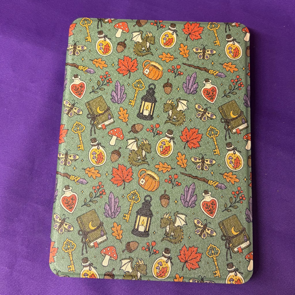 Green Witchy Woodland Autumn Kindle case patterned with mushrooms, leaves, potion bottles, books, moths and keys
